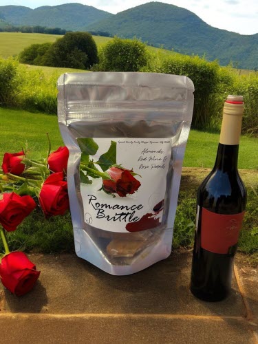 Romance Brittle bag in field with red wine bottle and roses