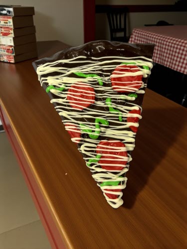 Dark chocolate potato chip pizza slice on countertop in pizzeria