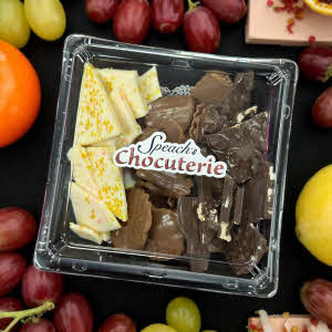 Chocuterie Tray with lid surrounded by various fruits and cheeses